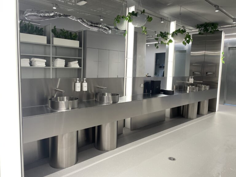 stainless steel vanity benchtop, circular drum below basin, and back panel with mirror